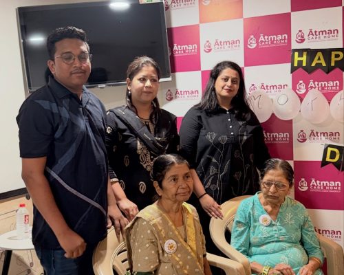 Atman Care Home staff standing with two senior women during a Mother's Day celebration.